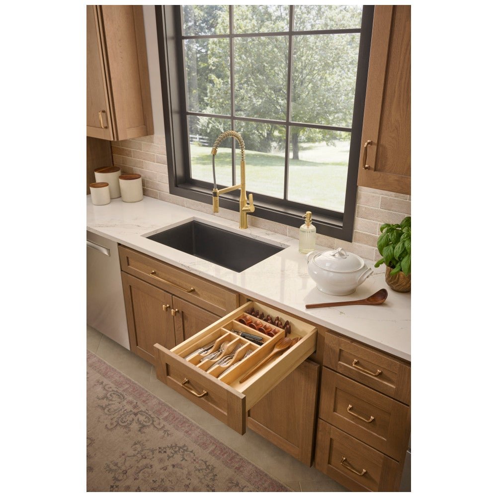 Birch cutlery drawer organizer in an open kitchen drawer by the sink