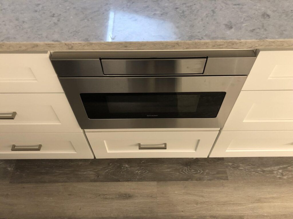 Stainless microwave drawer installed under a countertop