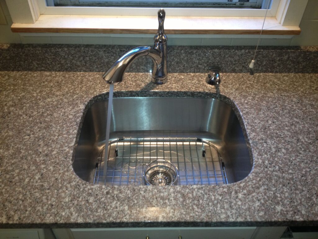 Large rectangle bowl stainless steel sink installed in a granite countertop