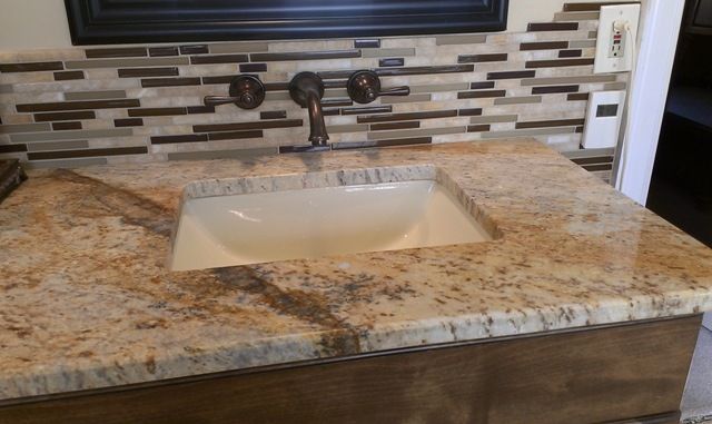 Rectangular ceramic vanity sink installed in a granite vanity top