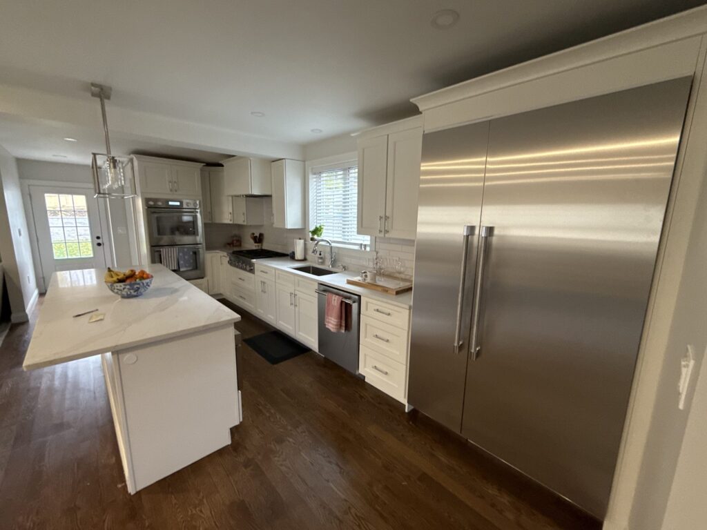 Gas range under a stainless hood with white subway tile backsplash – West Roxbury
