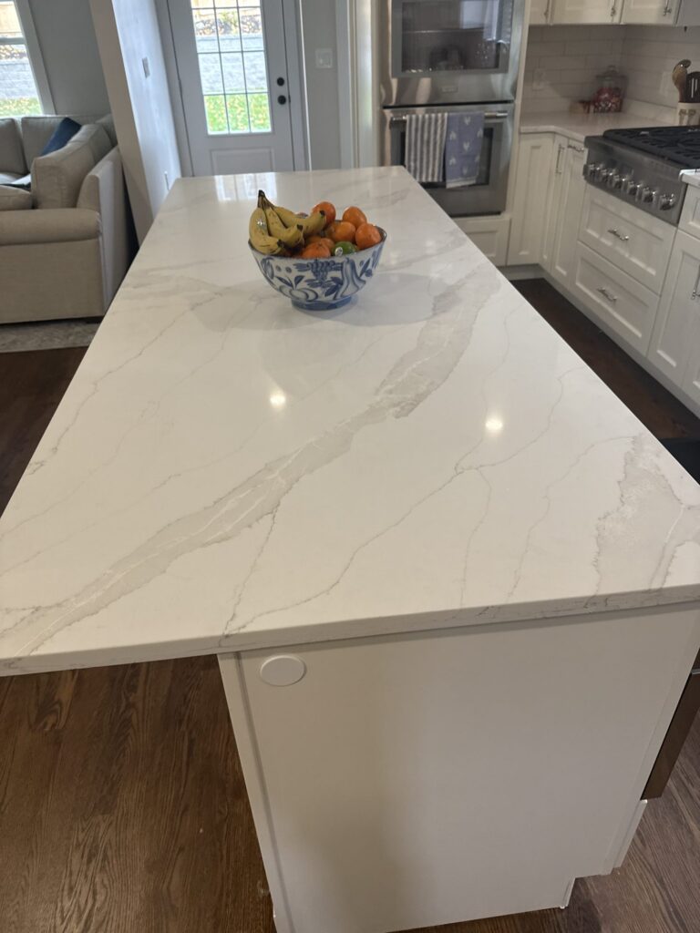 Marble-look quartz island with painted end panel – West Roxbury