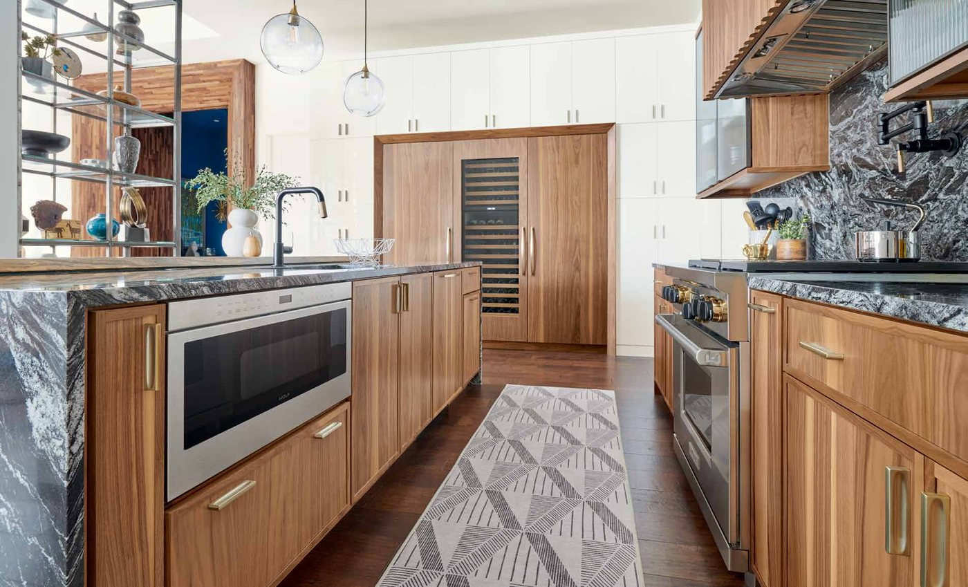 Omega walnut kitchen where pantry modifications align the upper doors with the refrigerator and wine cooler